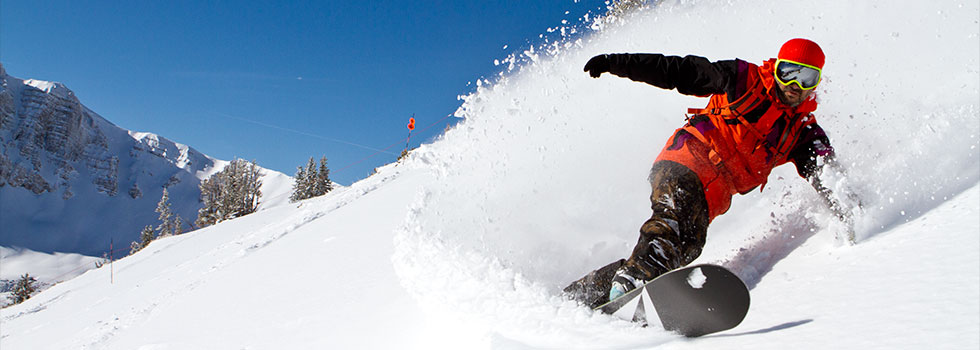 Foto Hombre de rojo bajando en snowboard